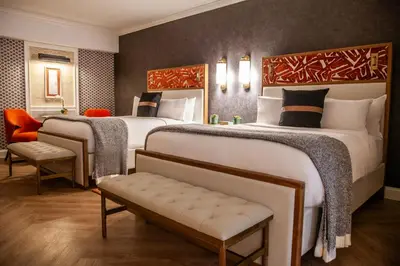 a hotel room with two beds and a chair at Delamar Westport in Westport