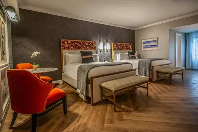 a hotel room with two beds and a table and chairs at Delamar Westport in Westport