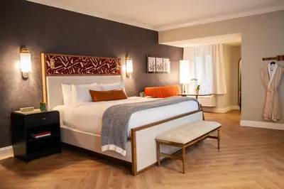 a hotel room with a large bed and a chair at Delamar Westport in Westport