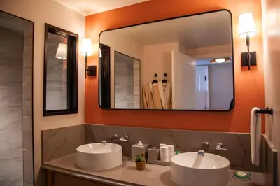 a bathroom with two sinks and a large mirror at Delamar Westport in Westport