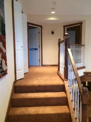 a hallway with stairs and a blue door in a house at MOUNT SNOW GREENSPRING 41d in West Dover