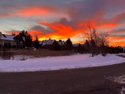 a sunset over a road with snow and houses at MOUNT SNOW GREENSPRING 41d in West Dover