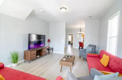 a living room with a red couch and a flat screen tv at Near NYC Spacious 4 bedroom 2 and a half bath in North Bergen