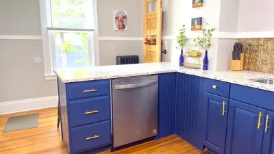 a kitchen with blue cabinets and a stainless steel dishwasher at The Rustic Home Albany NY - 3 Bedroom Private Second Floor Apartment in Albany