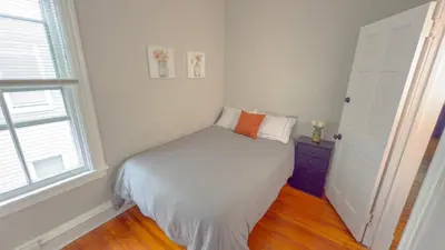 a small white bedroom with a bed and a window at The Rustic Home Albany NY - 3 Bedroom Private Second Floor Apartment in Albany