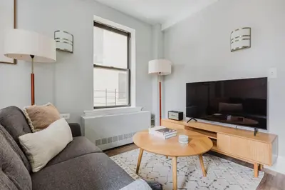 a living room with a couch and a tv at Blueground Upper West Side ac wd NYC-1546 in New York