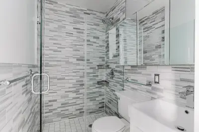 a bathroom with a toilet and a glass shower at Blueground Gramercy Park 2bd apartment NYC-1616 in New York
