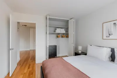 a bedroom with a bed and a walk in closet at Blueground Midtown West 1bd apartment NYC-1625 in New York