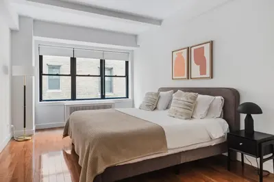 a white bedroom with a large bed and a window at Blueground Sutton Place 1bd apartment NYC-1630 in New York