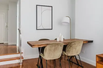 a dining room table with chairs and a mirror at Blueground Sutton Place 1bd apartment NYC-1630 in New York