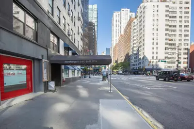 an empty street in a city with tall buildings at Blueground Sutton Place 1bd apartment NYC-1630 in New York