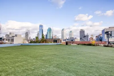 a large grassy field with a city in the background at Blueground Long Island City 1bd apartment NYC-1612 in New York