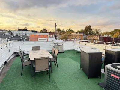a patio with tables and chairs on a roof at Stunning NYC rooftop views minutes away from NYC 2 bedroom 2 bath in Jersey City
