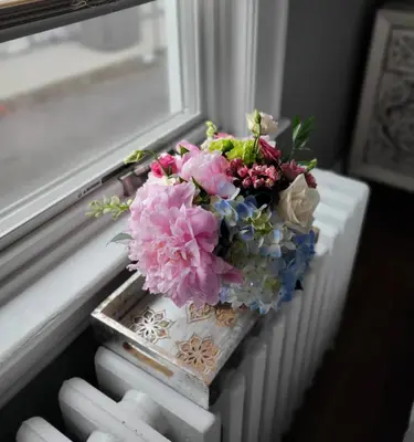 a bouquet of flowers sitting on a window sill at Gem by the water with firepit & all fenced backyard 2 Bedrooms in Stamford