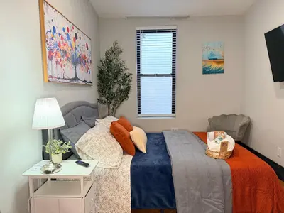 a bedroom with a bed and a table and a window at Bright & New Room Shared Apartment NYC Bus in Englewood