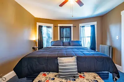 a large bed in a room with windows at Charming Chicopee Getaway in Chicopee