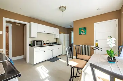 a kitchen with white cabinets and a table and chairs at Charming Chicopee Getaway in Chicopee