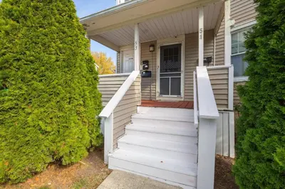 a white house with stairs leading to the front door at Charming Chicopee Getaway in Chicopee