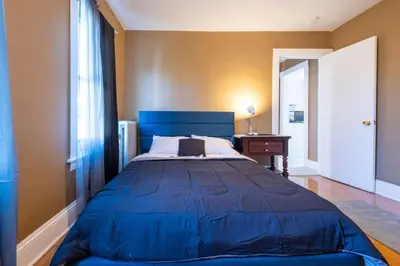 a large blue bed in a room with a window at Charming Chicopee Getaway in Chicopee