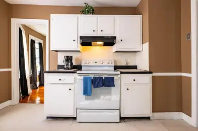 a kitchen with a white stove and white cabinets at Charming Chicopee Getaway in Chicopee