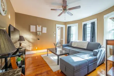 a living room with a couch and a ceiling fan at Charming Chicopee Getaway in Chicopee
