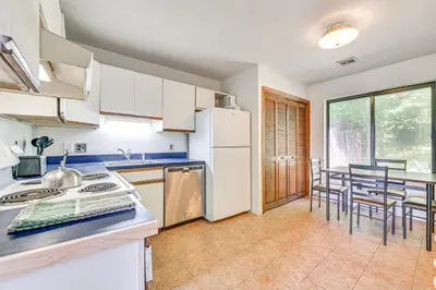a kitchen with white appliances and a table with chairs at Quiet Catskill Getaway with Fire Pit - Near Hiking! in Catskill