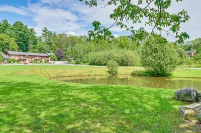 a pond in a yard with a house in the background at Quiet Catskill Getaway with Fire Pit - Near Hiking! in Catskill