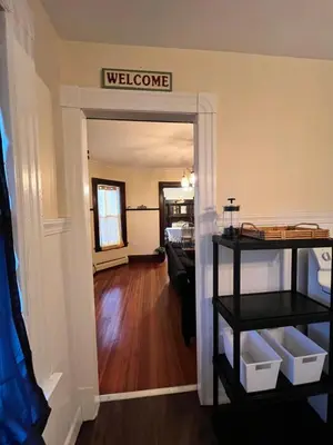 a living room with a welcome sign on the wall at Holyoke House Oasis - Calm Trips in Holyoke