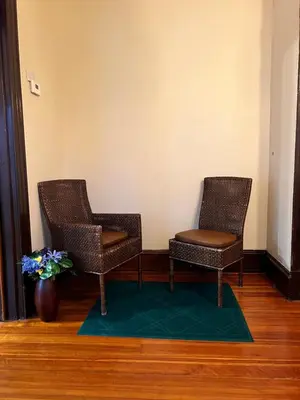 two chairs and a vase with flowers in a room at Holyoke House Oasis - Calm Trips in Holyoke