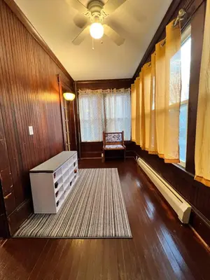 a living room with a ceiling fan and a table at Holyoke House Oasis - Calm Trips in Holyoke