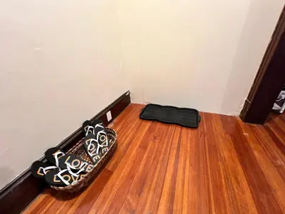 a room with a wooden floor and a black suitcase at Holyoke House Oasis - Calm Trips in Holyoke