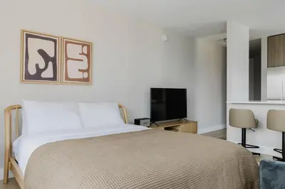 a bedroom with a bed and a flat screen tv at Blueground Upper East Side studio apartment NYC-1553 in New York