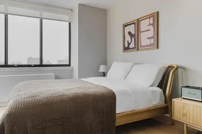 a bedroom with a bed and two windows at Blueground Upper East Side studio apartment NYC-1553 in New York