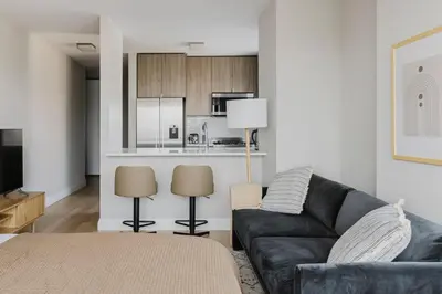 a living room with a couch and a kitchen at Blueground Upper East Side studio apartment NYC-1553 in New York