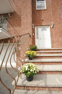 a staircase leading to a building with a door and flowers at Newark Liberty Brick House - Private Bedroom 2 in Newark
