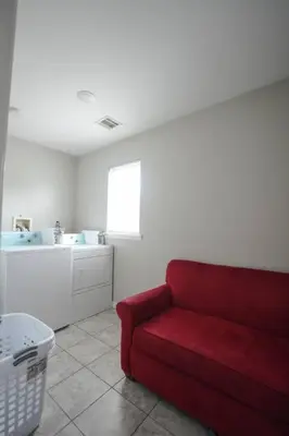 a living room with a red couch and a sink at Newark Liberty Brick House - Private Bedroom 3 in Newark