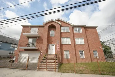 a red brick house with a white door at Newark Liberty Brick House - Private Bedroom 3 in Newark