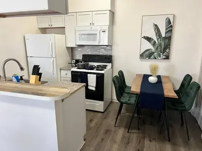 a kitchen with a table and a kitchen with white appliances at Affordable Stay Near Proctors A2 in Schenectady