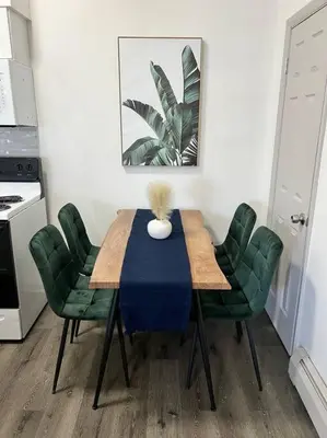 a dining room table with green chairs and a vase on it at Affordable Stay Near Proctors A2 in Schenectady