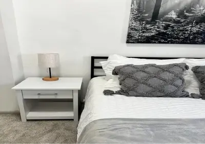a bedroom with a bed and a table with a lamp at Affordable Stay Near Proctors A2 in Schenectady