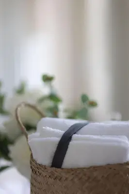 a basket filled with white towels with a black ribbon at Mt Williams Retreat in Williamstown
