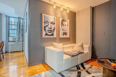 a living room with a white couch and pictures on the wall at Stylish 3Bd in Manhattan near the Empire State Building in New York