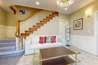 a living room with a white couch and stairs at Work, Play and Stay! Apt Near Holyoke Medical Center in Holyoke