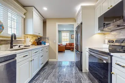 a kitchen with white cabinets and black appliances at Work, Play and Stay! Apt Near Holyoke Medical Center in Holyoke