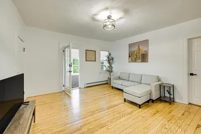 an empty living room with a couch and a table at NYC Area Apartment on Hudson River! in Hastings-on-Hudson