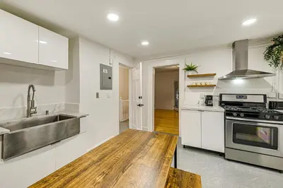 a kitchen with white cabinets and a sink and a stove at NYC Area Apartment on Hudson River! in Hastings-on-Hudson