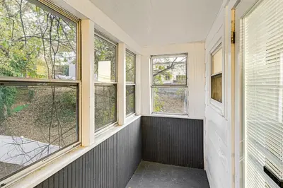 an empty room with windows and a balcony at NYC Area Apartment on Hudson River! in Hastings-on-Hudson