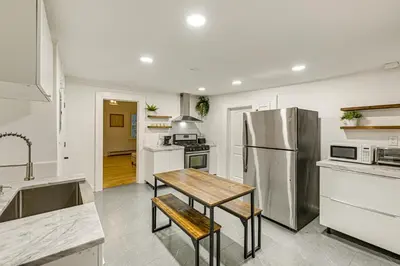 a kitchen with a table and a stainless steel refrigerator at NYC Area Apartment on Hudson River! in Hastings-on-Hudson