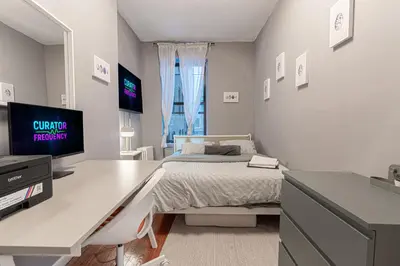 a bedroom with a desk with a bed and a tv at Charming 3Bd in Manhattan in New York