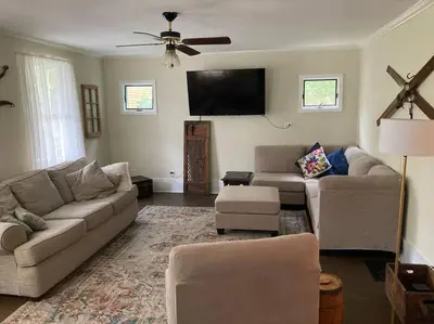 a living room with a couch and a flat screen tv at Victorian Farmhouse in The Catskills in East Meredith